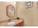 Stylish powder room with granite countertop and decorative mirror at 980 Yancey Ct, Loganville, GA 30052