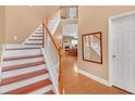 Elegant staircase with wooden railings and white risers leading to the upper level at 980 Yancey Ct, Loganville, GA 30052