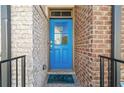 Inviting entryway featuring a vibrant blue door framed by classic brickwork and a welcoming 'hello' mat at 2145 Old Georgian Nw Ter, Atlanta, GA 30318