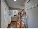 Inviting entryway features hardwood floors, staircase with iron spindles, and a view into the spacious living room at 452 Springfield Dr, Woodstock, GA 30188