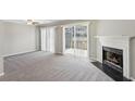 Inviting living room featuring a fireplace, plush carpeting, and sliding door to the outside at 543 Harbor Lake Ct, Marietta, GA 30066