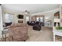 Spacious living room featuring plush carpeting, a stone fireplace, and ample seating perfect for entertaining at 6525 Oak Highlands Ct, Cumming, GA 30041