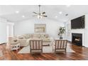 Bright living room with wood floors, fireplace, and ceiling fan at 6800 Bells Landing Way, Rex, GA 30273