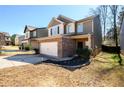 View of a two-story home featuring a brick-accented facade, attached two-car garage, and landscaping at 103 Magnaview Dr, Mcdonough, GA 30253