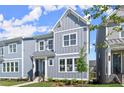 Stylish townhome featuring gray vertical siding, a covered entry, and pristine landscaping at 1941 Quarry Park Nw Pl, Atlanta, GA 30318