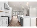 Open-concept kitchen featuring stainless steel appliances, white cabinets, and spacious center island at 1941 Quarry Park Nw Pl, Atlanta, GA 30318