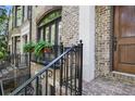 Close-up of a brick townhome's facade, featuring a wrought iron railing and lush greenery at 8 Honour Nw Ave # 6, Atlanta, GA 30305