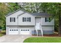 Two story home with light gray siding, black shutters, and front landscaping at 152 Country Cottage Cir, Carrollton, GA 30116
