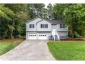 Two story home with light gray siding, black shutters, two-car garage and front landscaping at 152 Country Cottage Cir, Carrollton, GA 30116