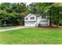 Two story home with light gray siding, black shutters, two-car garage and large lawn at 152 Country Cottage Cir, Carrollton, GA 30116