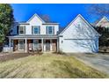 Traditional home featuring a covered porch, shutters, and an attached two-car garage at 2389 Lake Villas Ln, Duluth, GA 30097