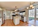Well-lit kitchen with granite countertops, island, stainless appliances, and hardwood floors at 2389 Lake Villas Ln, Duluth, GA 30097