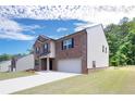 Side view of a brick home with siding, showcasing the driveway and well-maintained lawn at 5417 Flat Rock Point, Stonecrest, GA 30038