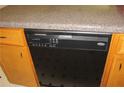 Close-up of a black dishwasher with simple controls and light wood cabinetry in a kitchen at 661 White Bird Way, Fairburn, GA 30213