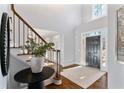Inviting foyer features a high ceiling, hardwood floors and a modern black front door at 1229 Ellington Ct, Cumming, GA 30041