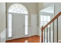 Bright foyer with hardwood floors, transom window, and staircase to upper level at 251 Vinings Retreat Sw Vw, Mableton, GA 30126