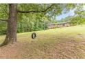 Spacious backyard with a tire swing hanging from a mature tree, perfect for outdoor fun and relaxation at 5255 Post Rd, Winston, GA 30187