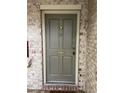 Stylish gray front door featuring classic paneling and brass hardware on a brick building at 8 Cantey Nw Pl, Atlanta, GA 30327