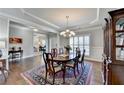 Dining room featuring hardwood floors, chandelier, and large window shutters at 4830 Amble Trce, Cumming, GA 30040