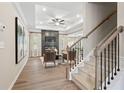 Comfortable living room view from the stairs showcasing a modern fireplace, wood floors, and tray ceiling at 145 Silver Leaf Trce, Douglasville, GA 30134