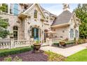 Stunning stone home featuring manicured landscaping with a covered porch and a blue front door at 165 Ansley Way, Roswell, GA 30075