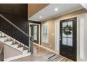 Warm entryway featuring a stylish black front door and staircase with black spindles at 3186 Quail Ct, Decatur, GA 30034