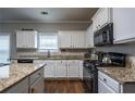 Bright kitchen featuring white cabinets, granite countertops, and modern appliances at 26 Crescent Ln, Dallas, GA 30157