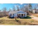 Inviting single-story home featuring a covered front porch with seating, complemented by a well-maintained lawn at 2951 N Mckoy Rd, Villa Rica, GA 30180