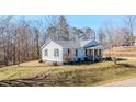 Quaint one-story home on a sloped lot, featuring a welcoming covered porch and neatly trimmed landscaping at 2951 N Mckoy Rd, Villa Rica, GA 30180