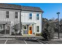 Charming townhome featuring a stylish exterior, landscaped front yard, and a vibrant orange front door at 697 Fayetteville Rd # 303, Atlanta, GA 30316