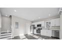 Bright and airy kitchen featuring white cabinetry, stainless steel appliances, and durable gray wood floors at 697 Fayetteville Rd # 303, Atlanta, GA 30316