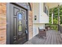 Close-up of the front door with stone accent, covered porch and seating area at 509 Chestnut Oak Dr, Palmetto, GA 30268
