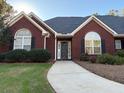 Inviting brick home featuring a well-lit walkway to the front door at 625 Huiet Dr, Mcdonough, GA 30252