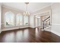 A bright foyer with hardwood floors, crown molding, staircase, and a chandelier at 120 Pine Mist Cir, Alpharetta, GA 30022