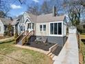 Lovely home featuring an enclosed porch and an expansive driveway leading to a detached garage at 1891 W Forrest Ave, Atlanta, GA 30344