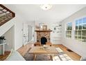 Sun-drenched living room featuring hardwood floors, a stone fireplace, and built-in bookshelves at 1891 W Forrest Ave, Atlanta, GA 30344