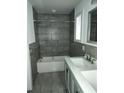 Stylish bathroom boasting gray tiled walls, a modern sink, and a shower/tub combo at 2791 Allegro Nw Dr, Atlanta, GA 30318