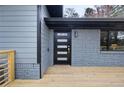 Front entrance with sleek black door, modern details, painted brick and a new wood deck at 1120 Taliwa Ne Trl, Marietta, GA 30068