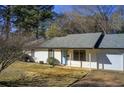 Inviting single-story home with white siding, a blue front door, and a well-manicured lawn at 170 Roberts Rd, Covington, GA 30016