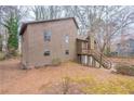 Exterior view of the rear of the house, showing the windows and wooded backyard at 123 Williamsburg Ln, Woodstock, GA 30189