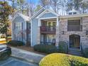 View of lovely condo building with stacked stone accents, private balconies, and manicured landscaping at 301 Madison Se Ct # 301, Smyrna, GA 30080