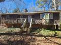 View of a home with wood siding, a front porch, and visible brick foundation at 6575 Riley Rd, Cumming, GA 30028