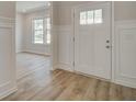 Bright entryway showcasing hardwood floors, decorative wall paneling, and a stylish front door at 308 Moab Ct, Stockbridge, GA 30281