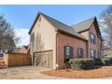 Side view of the brick home featuring a two-car garage and fenced yard at 3215 Belford Drive, Marietta, GA 30066