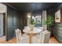 Dark and cozy dining room with wainscotting, modern lighting and seating for four at 886 Cedar Creek Se Ct, Marietta, GA 30067