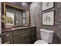 Charming powder room featuring dark vanity, decorative wallpaper, and framed art at 886 Cedar Creek Se Ct, Marietta, GA 30067