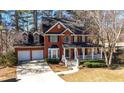 Attractive two-story brick home featuring a covered front porch and an attached two-car garage at 9937 Between The Grns, Villa Rica, GA 30180