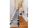 Elegant staircase featuring hardwood floors, a dark wood banister, and neutral wall colors at 9937 Between The Grns, Villa Rica, GA 30180