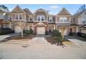 Two-story townhomes feature brick and siding exteriors, individual garages, and professionally landscaped front yards at 1094 N Village Dr, Decatur, GA 30032