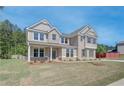 Inviting two-story home with brick and neutral siding, surrounded by greenery and a freshly cut lawn at 226 Linford Dr, Locust Grove, GA 30248